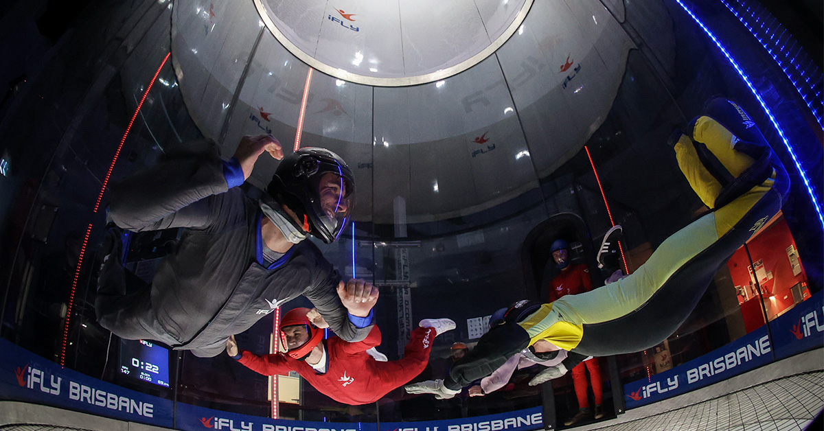 Three skydivers in a wind tunnel