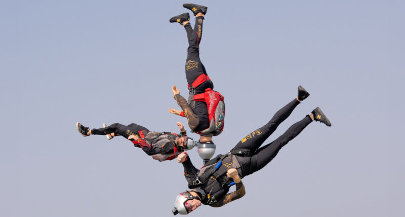Three skydivers in freefall, upside down