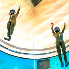 Two skydivers practice in a wind tunnel.