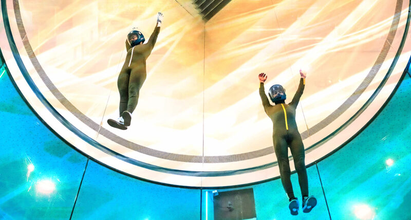 Two skydivers practice in a wind tunnel.