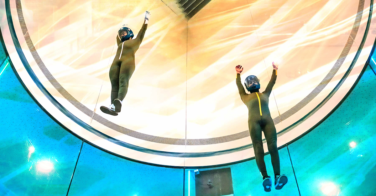 Two skydivers practice in a wind tunnel.