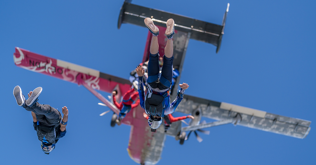 Three skydivers dropping from a plane.