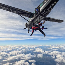 Skydiver jumping from a plane, above cloud level