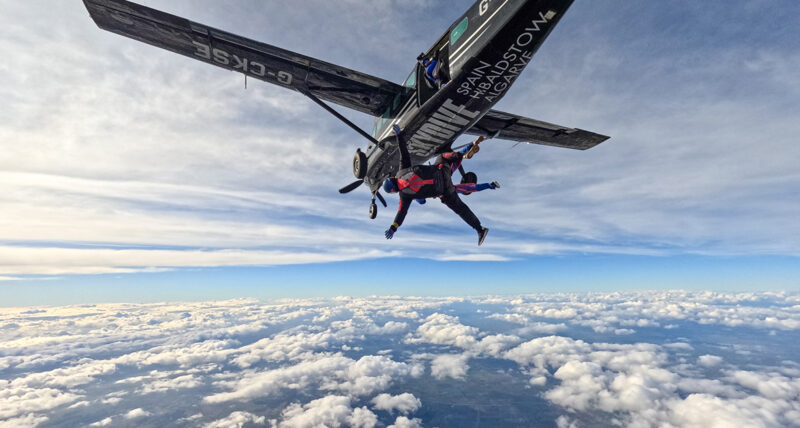 Skydiver jumping from a plane, above cloud level