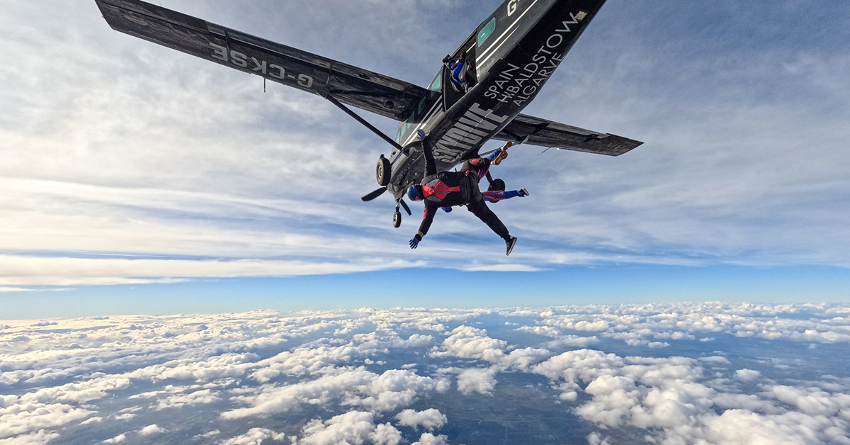 Skydiver jumping from a plane, above cloud level