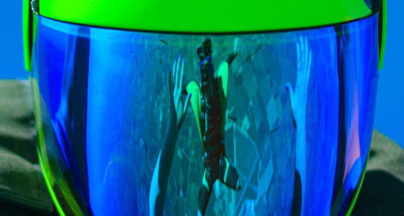 Reflection of a wingsuiter in the helmet of a skydiver