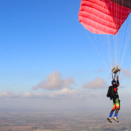 Skydiving gliding through the clouds with their parachute open