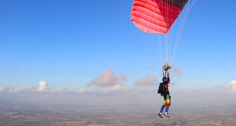 Skydiving gliding through the clouds with their parachute open