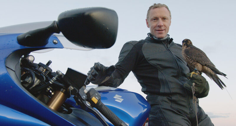 Andy Torbet poses with his Suzuki motorcycle and a peregrine falcon