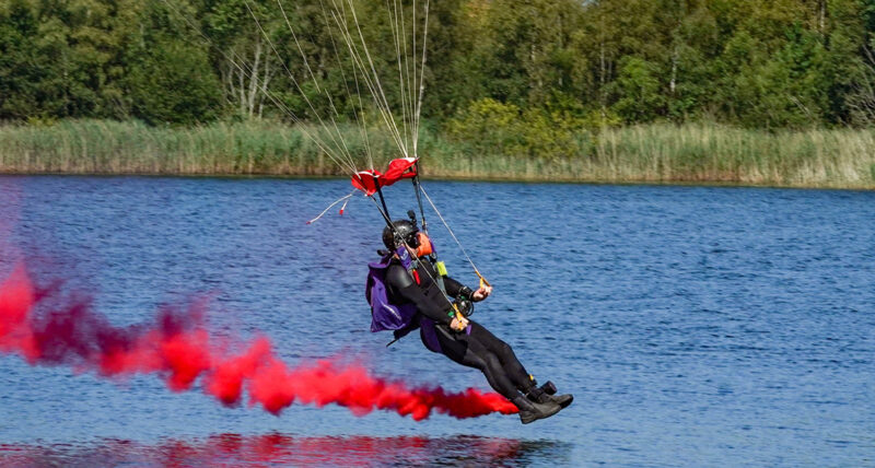 Andy Torbet about to touch down on water, trailing red smoke