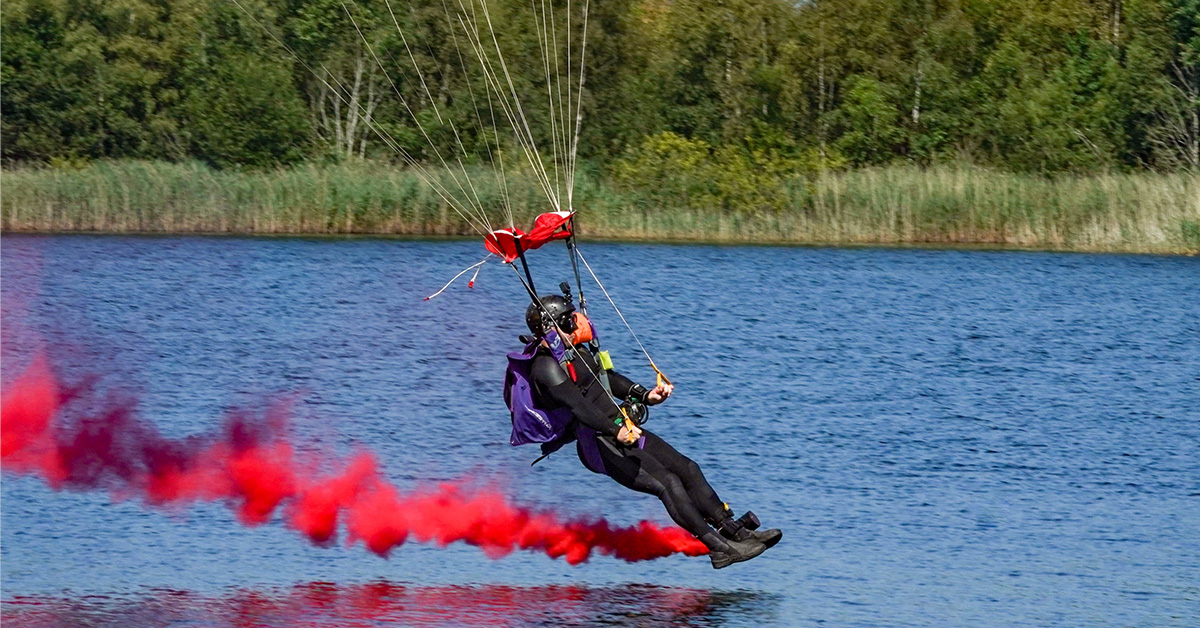 Andy Torbet about to touch down on water, trailing red smoke