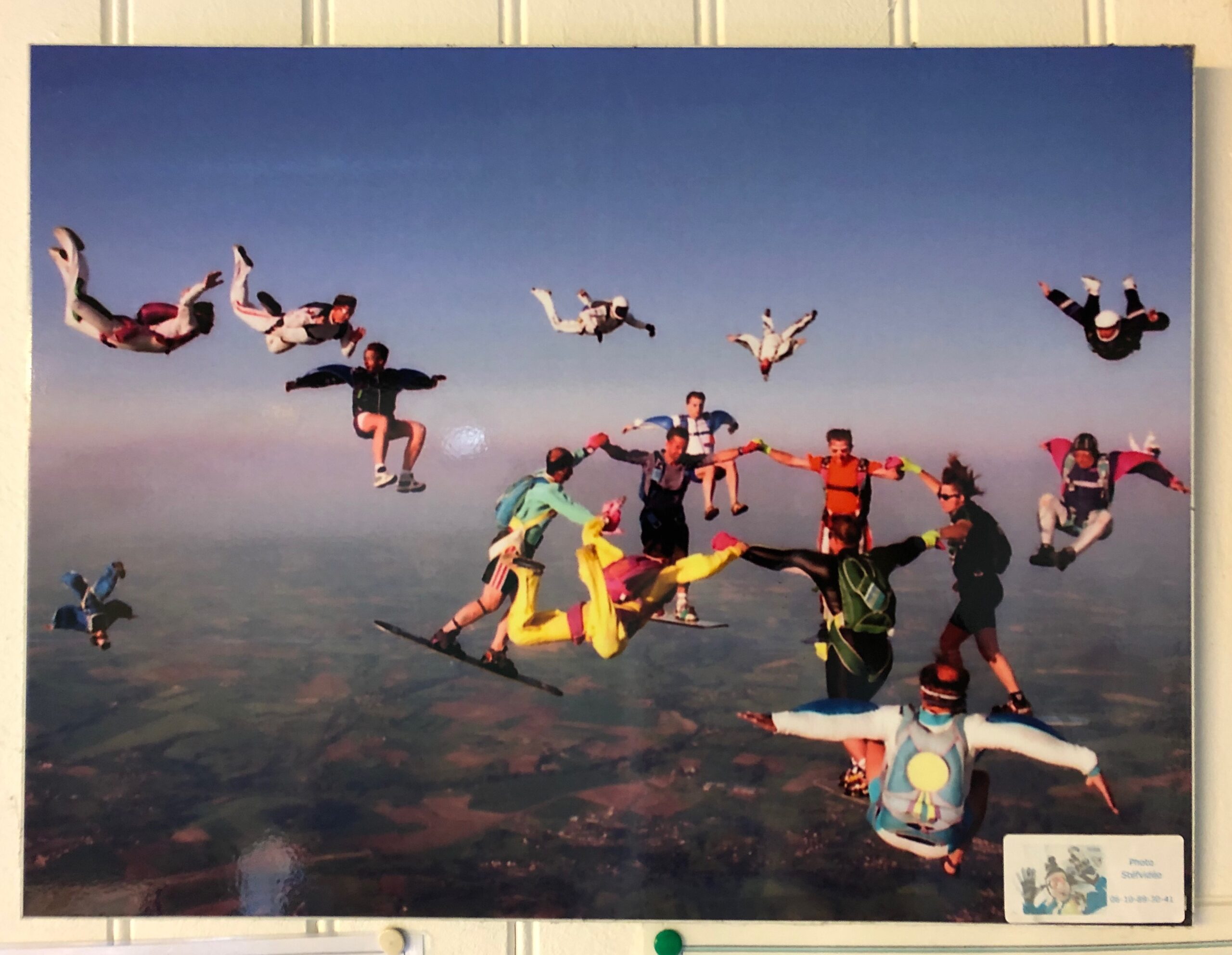 An old photograph of skydivers coming together mid-freefall.