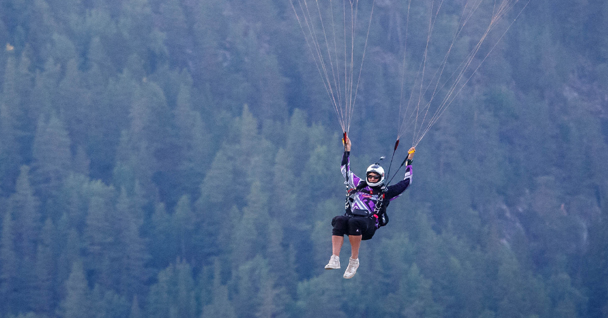 Joel Strickland glides down under a chute.