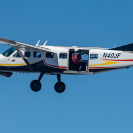 A skydiver prepares to leave a plane.