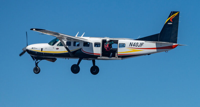 A skydiver prepares to leave a plane.
