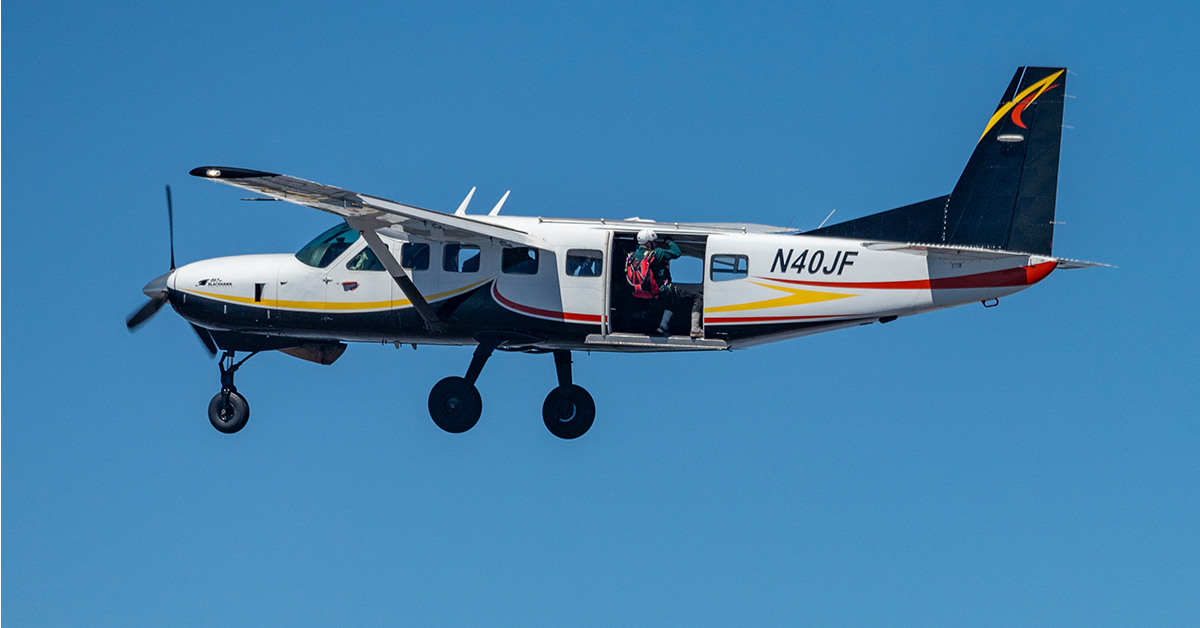 A skydiver prepares to leave a plane.